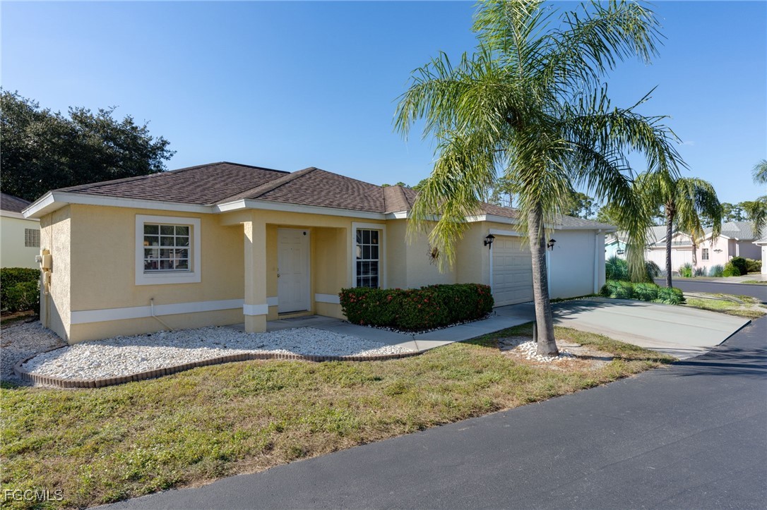 10741 Rio Mar Circle Estero, FL 33928 - Photo 1 of 23 a front view of house with yard and trees around