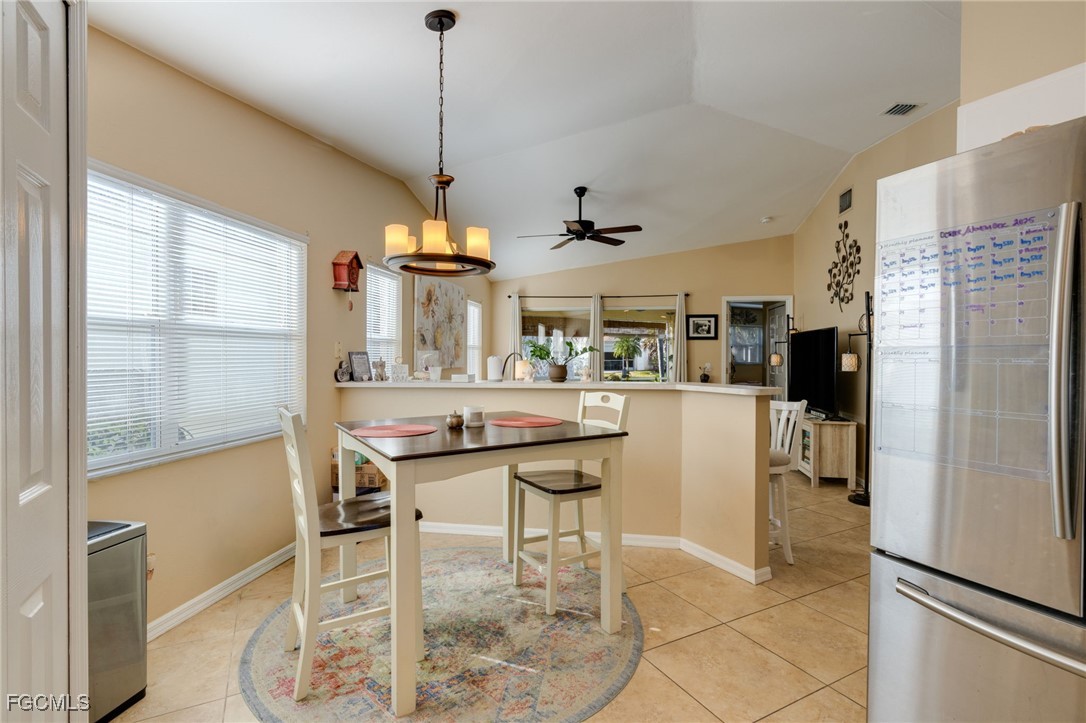 10741 Rio Mar Circle Estero, FL 33928 - Photo 13 of 23 a kitchen with stainless steel appliances granite countertop a refrigerator a sink a stove and chairs