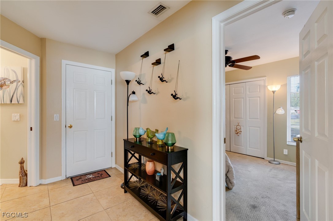 10741 Rio Mar Circle Estero, FL 33928 - Photo 7 of 23 a view of an entryway with a flower pot and a bookshelf