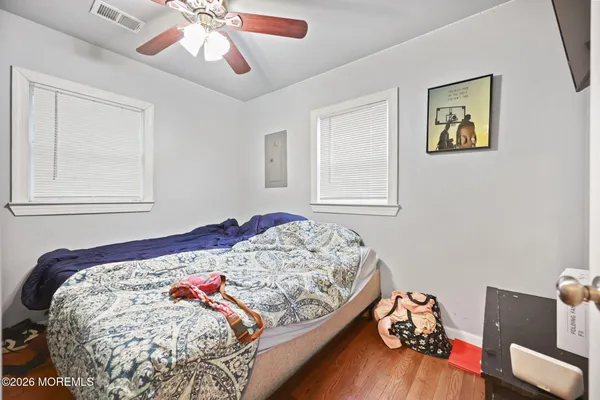 a bedroom with a bed and wooden floor