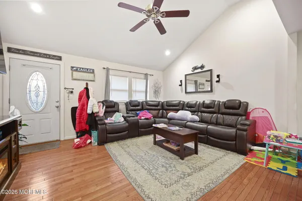 a living room with furniture a clock and a window