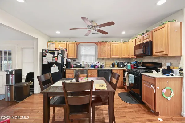 a kitchen with stainless steel appliances granite countertop a stove a sink a microwave a dining table and chairs
