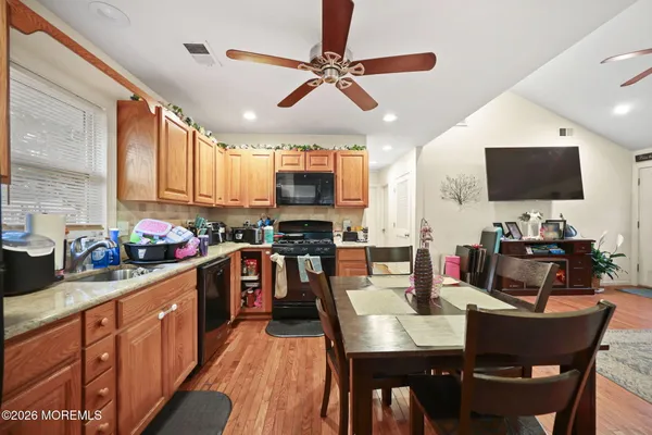 a kitchen with stainless steel appliances kitchen island granite countertop a sink a stove a dining table and chairs