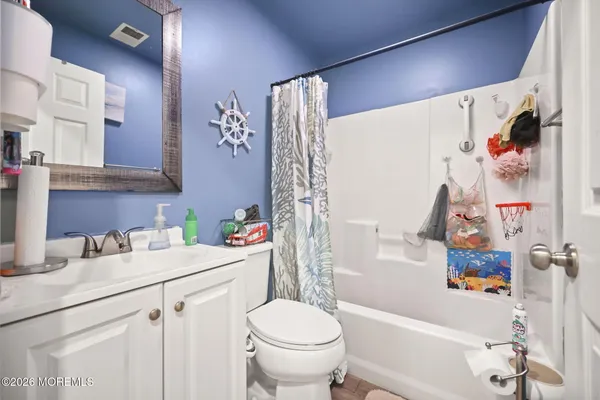 a bathroom with a sink a toilet and a shower curtain