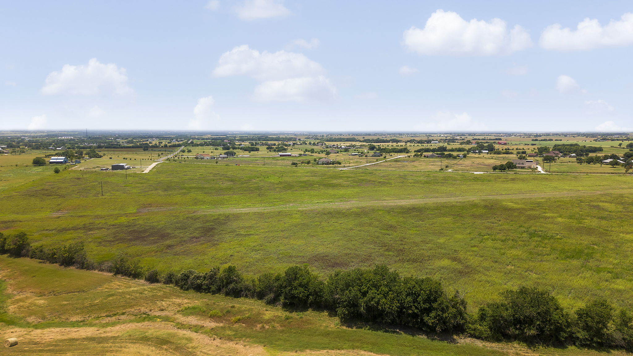 Rolling green acreage unfolds, offering ample space for a rural retreat.
