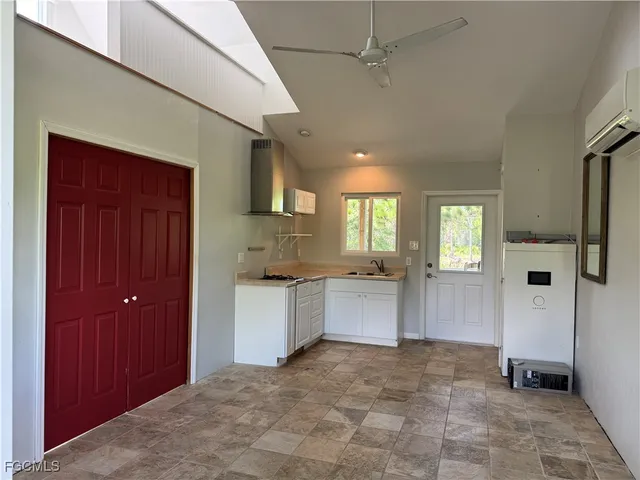 a large white kitchen with a sink and dishwasher a oven with wooden floor