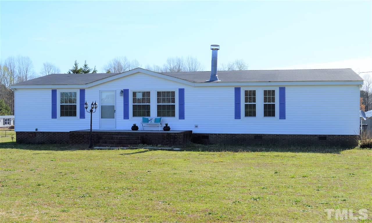 8701 Walter Myatt Road Willow Spring, NC 27592 - Photo 1 of 13 a front view of a house with a garden