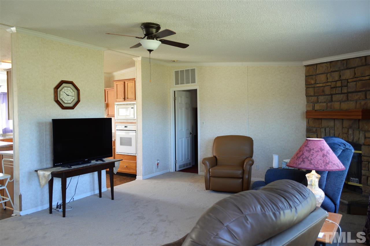 8701 Walter Myatt Road Willow Spring, NC 27592 - Photo 4 of 13 a living room with furniture and a flat screen tv