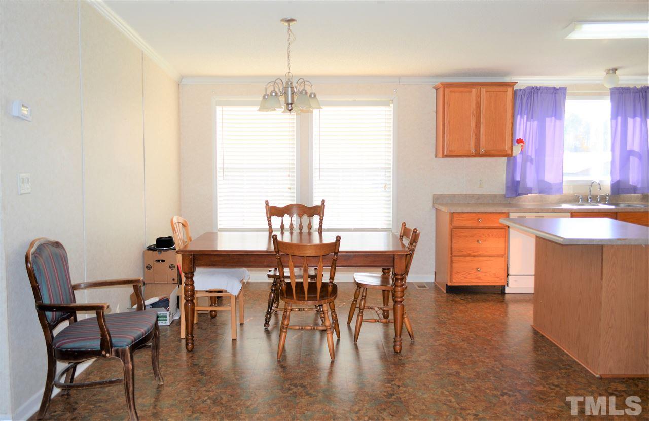 8701 Walter Myatt Road Willow Spring, NC 27592 - Photo 5 of 13 a dining room with furniture a chandelier and wooden floor