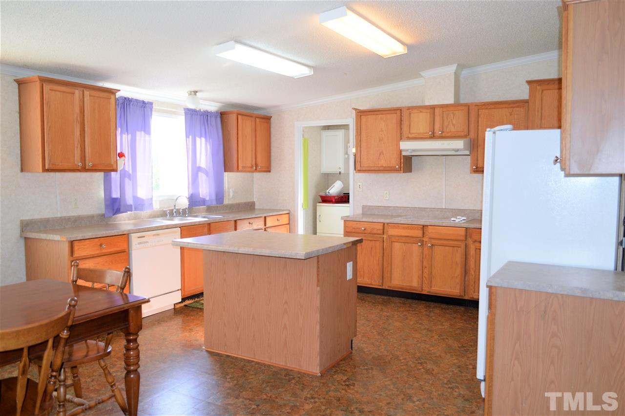 8701 Walter Myatt Road Willow Spring, NC 27592 - Photo 6 of 13 a kitchen with a sink a counter top space and stainless steel appliances