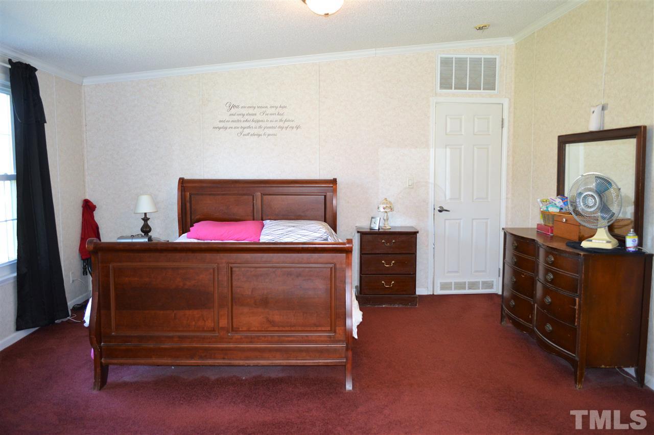 8701 Walter Myatt Road Willow Spring, NC 27592 - Photo 7 of 13 a bed room with a bed and a dresser