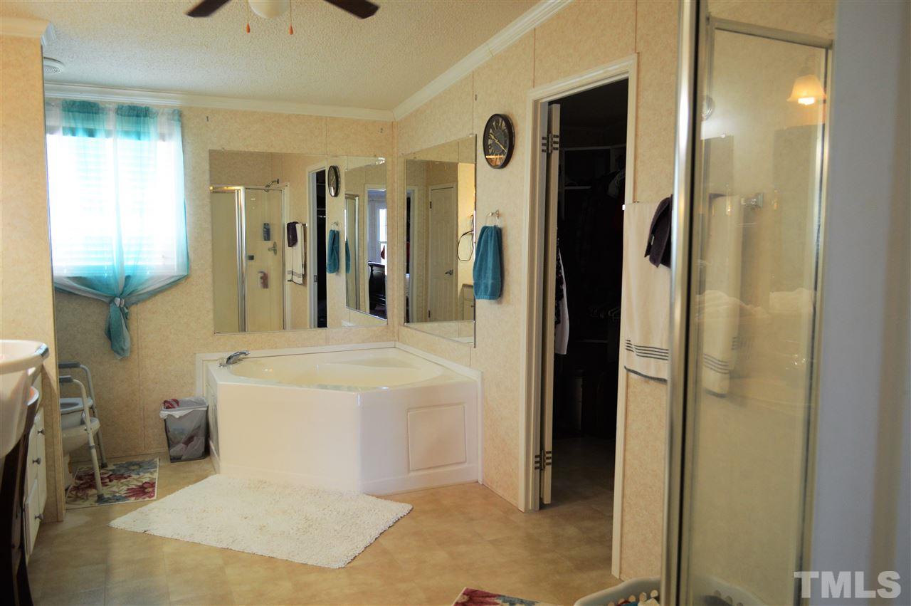 8701 Walter Myatt Road Willow Spring, NC 27592 - Photo 9 of 13 a bathroom with a sink a toilet and shower