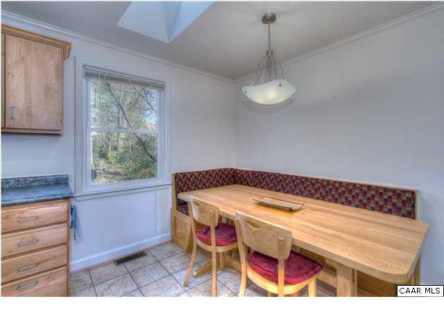 1407 Rutledge Avenue Charlottesville, VA 22903 - Photo 9 of 24 A maple banquette, custom-built to fit the space conveys with the home. Tucked under a large window and a skylight, it's a bright and cozy corner for dining.