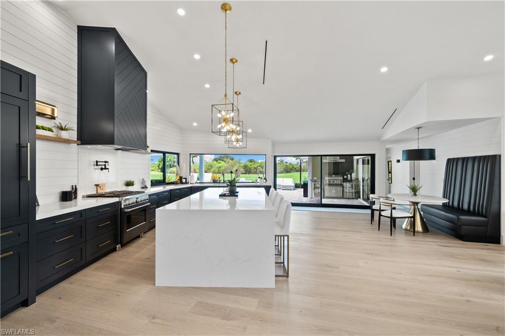 19559 Vintage Trace Circle Estero, FL 33967 - Photo 12 of 50 a large kitchen with kitchen island a large island in the center and stainless steel appliances