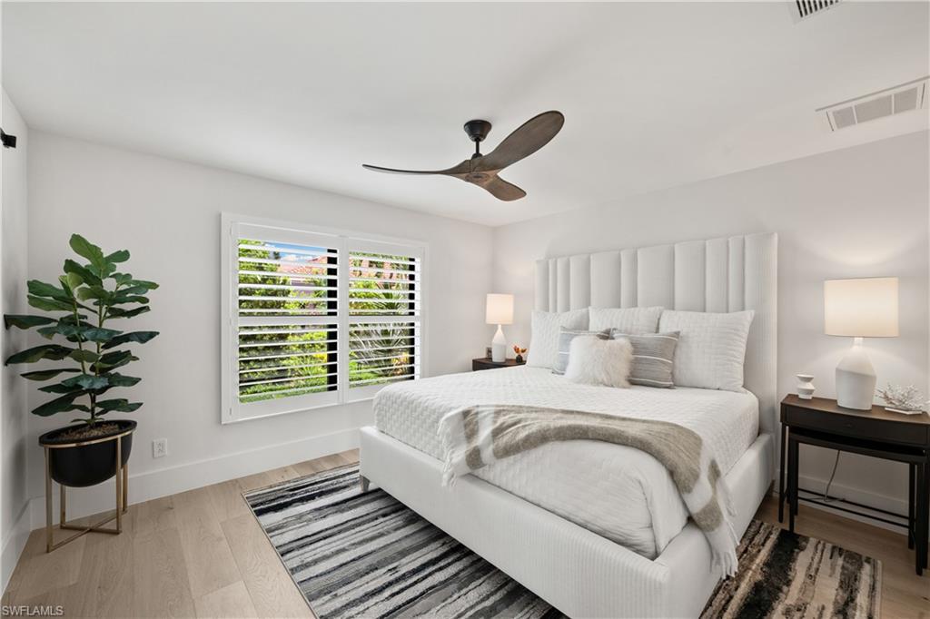 19559 Vintage Trace Circle Estero, FL 33967 - Photo 36 of 50 a bedroom with a large bed and a chandelier