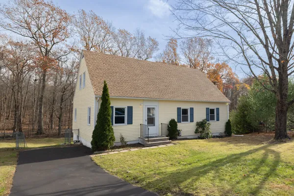 a front view of house with yard and trees around