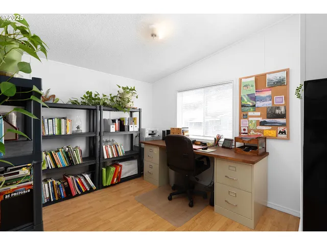 a view of a workspace with furniture and a book shelf