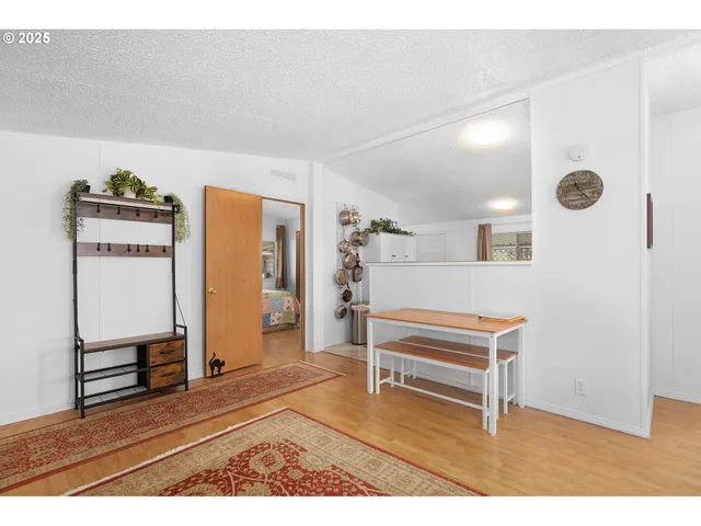a living room with a piano and a table with wooden floor