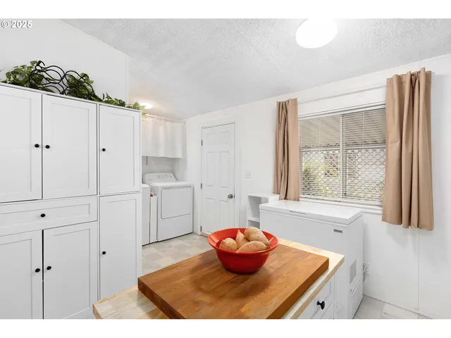 a kitchen with white cabinets and window