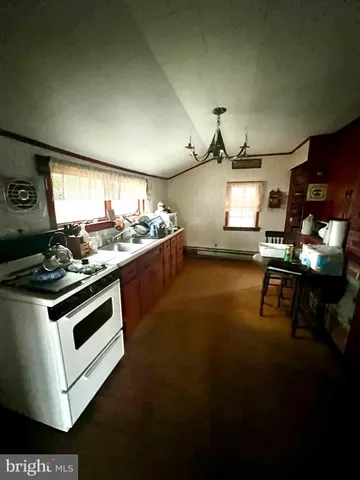 a kitchen with a stove and a wooden floor
