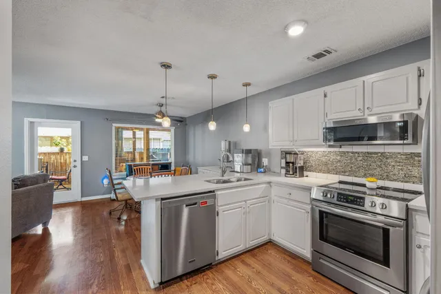 a kitchen with white cabinets and stainless steel appliances