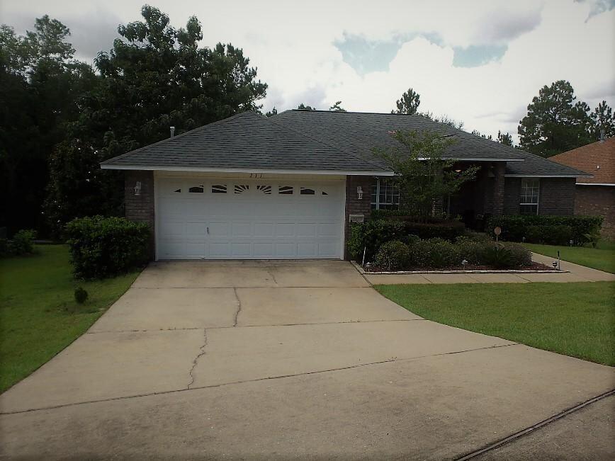 a front view of house with yard and trees