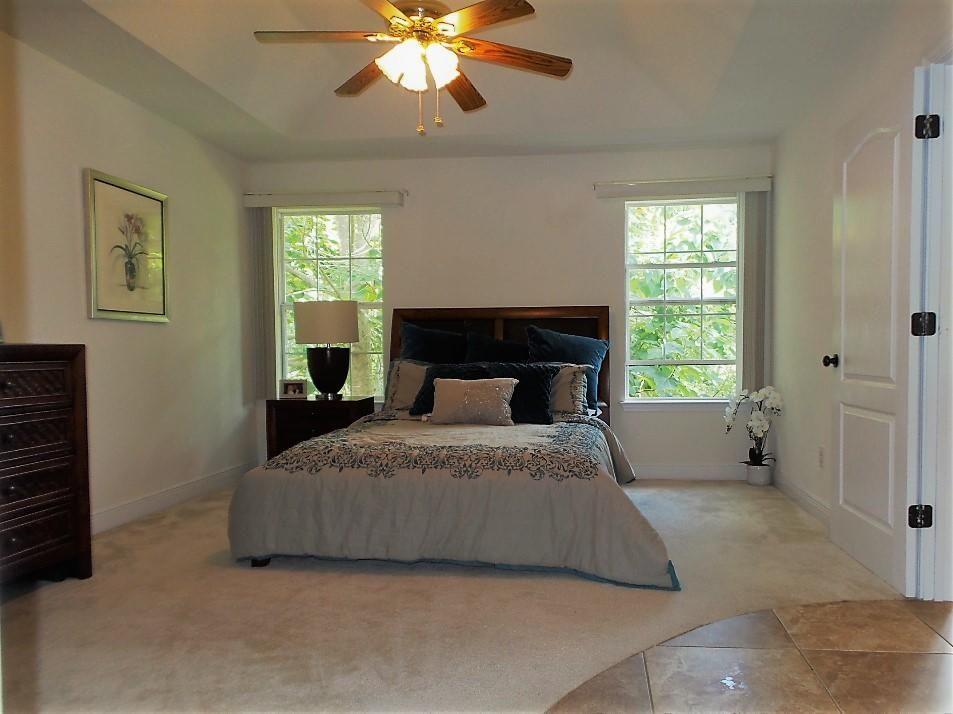 211 Foxchase Way Crestview, FL 32536 - Photo 14 of 24 a spacious bedroom with a bed and a chandelier