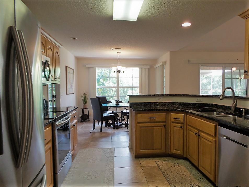 211 Foxchase Way Crestview, FL 32536 - Photo 9 of 24 a kitchen with stainless steel appliances granite countertop a refrigerator a sink a stove a dining table and chairs