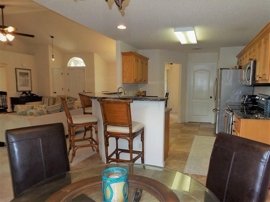 211 Foxchase Way Crestview, FL 32536 - Photo 10 of 24 a open kitchen with stainless steel appliances kitchen island granite countertop a sink a stove a dining table and chairs