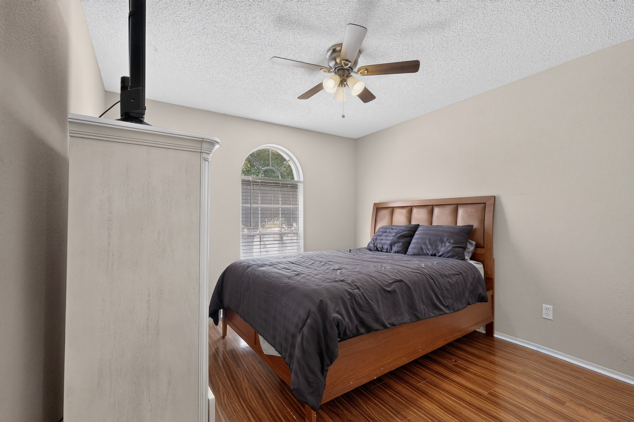 1601 Rusty Nail Loop Round Rock, TX 78681 - Photo 14 of 23 Laminate flooring and an arched window define this inviting bedroom space.