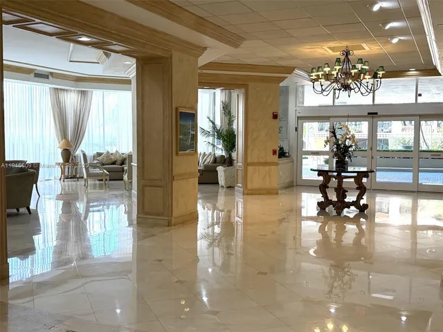 a hallway with dining area and chandelier