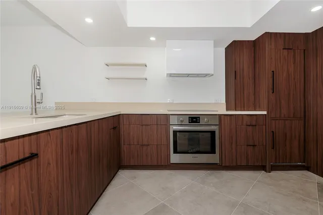 a kitchen with stainless steel appliances granite countertop wooden cabinets a stove and a sink