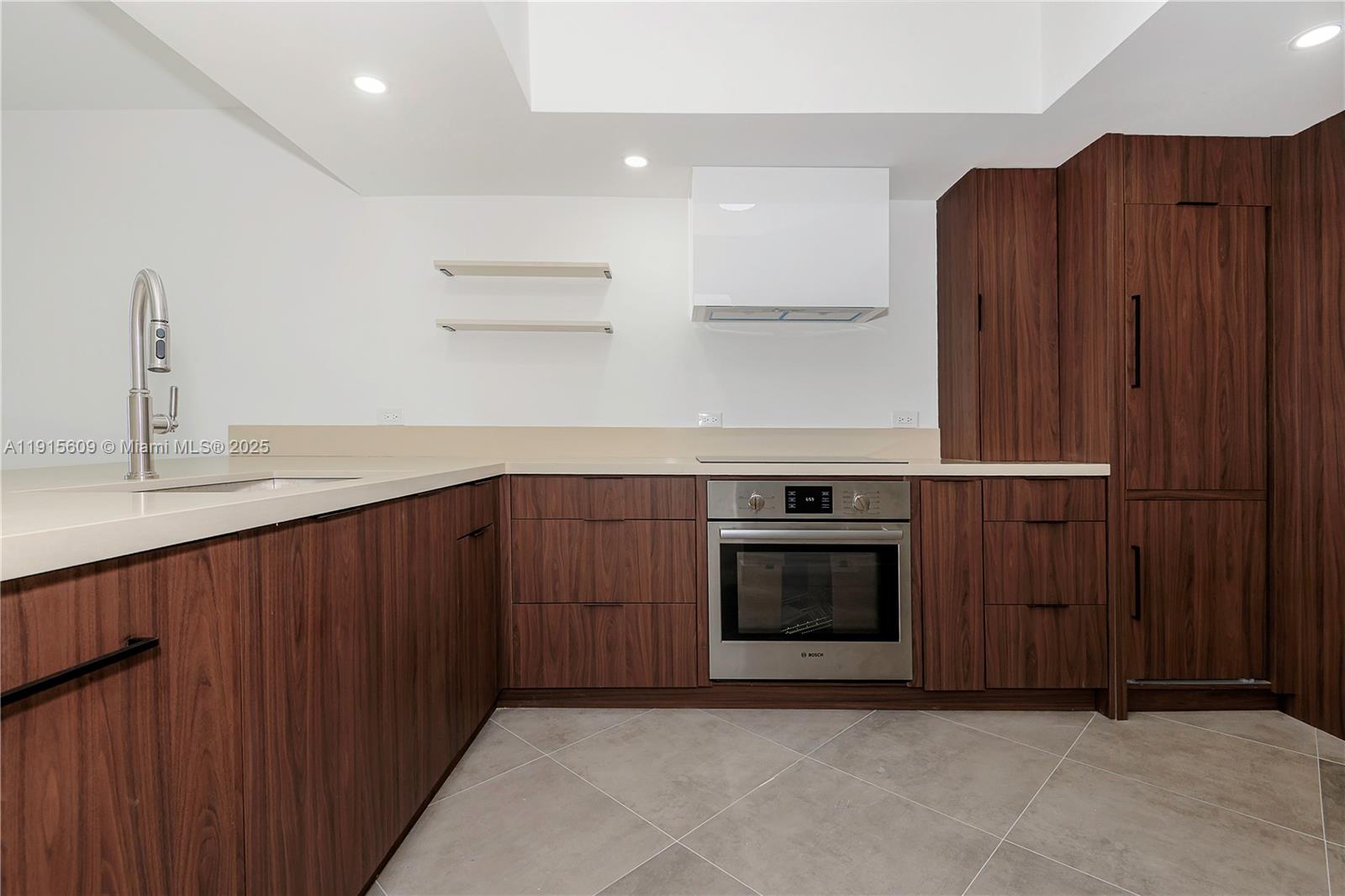 8855 Collins Avenue, Unit 6E Surfside, FL 33154 - Photo 8 of 24 a kitchen with stainless steel appliances granite countertop wooden cabinets a stove and a sink