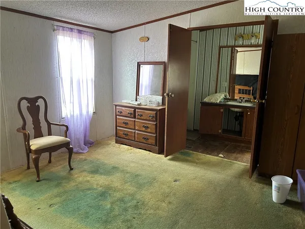 a spacious bedroom with a bed and a mirror