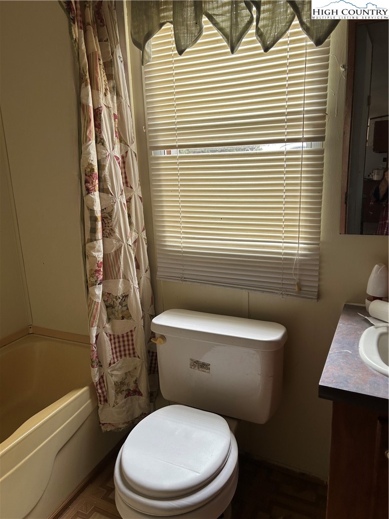 223 Poplar Lane Lansing, NC 28643 - Photo 9 of 12 a white toilet sitting next to a bathroom sink