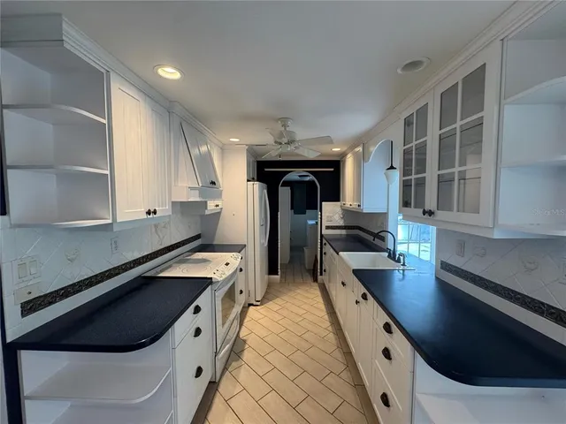 a kitchen with stainless steel appliances granite countertop a sink a stove and a refrigerator