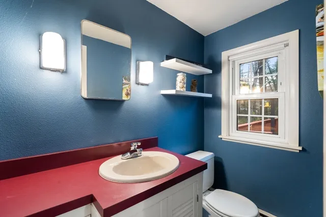 a bathroom with a toilet sink and mirror
