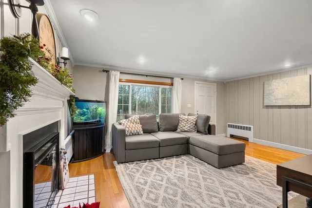 a living room with furniture fireplace and a large window