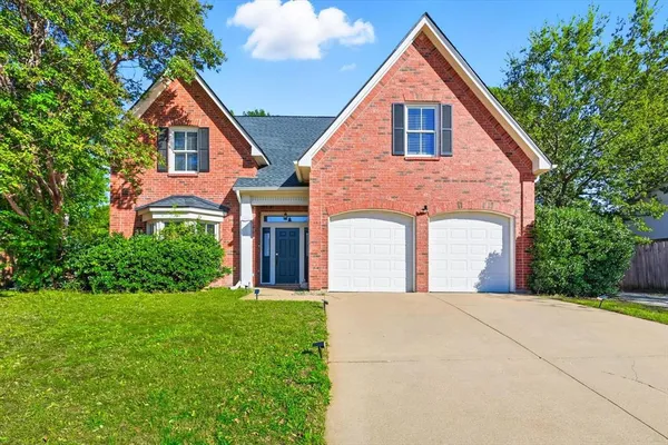 a front view of a house with yard and green space