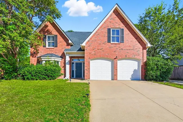 a front view of a house with yard and green space