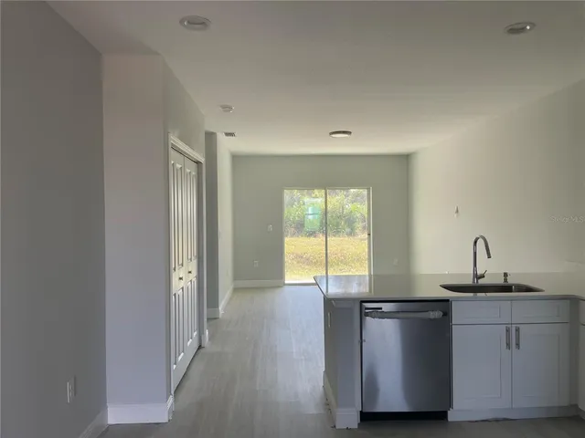 a kitchen with stainless steel appliances granite countertop a sink and a hard wood floor