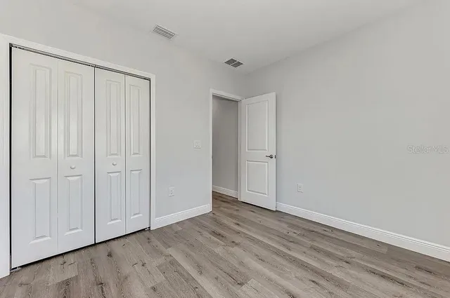 a view of an empty room with wooden floor