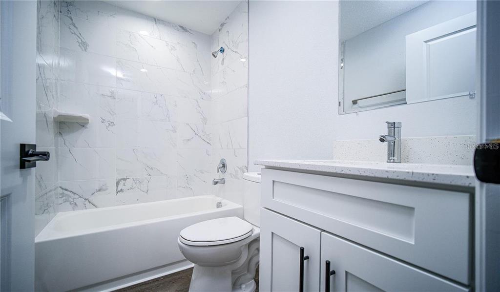 10249 Burlington Avenue Englewood, FL 34224 - Photo 6 of 12 a bathroom with a sink a toilet and shower