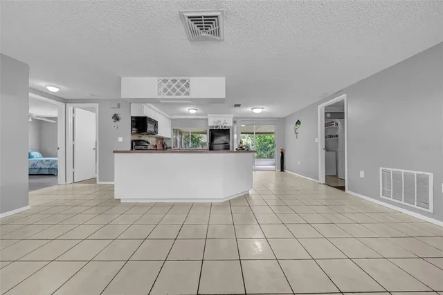 a view of a kitchen with kitchen island a counter top space stainless steel appliances and cabinets