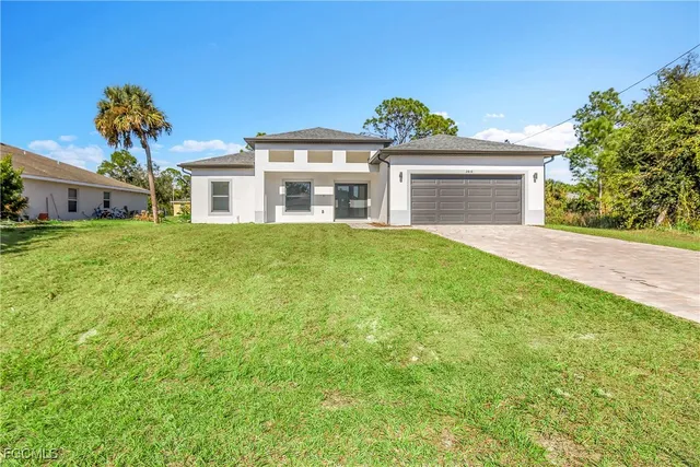 a front view of a house with a garden and yard