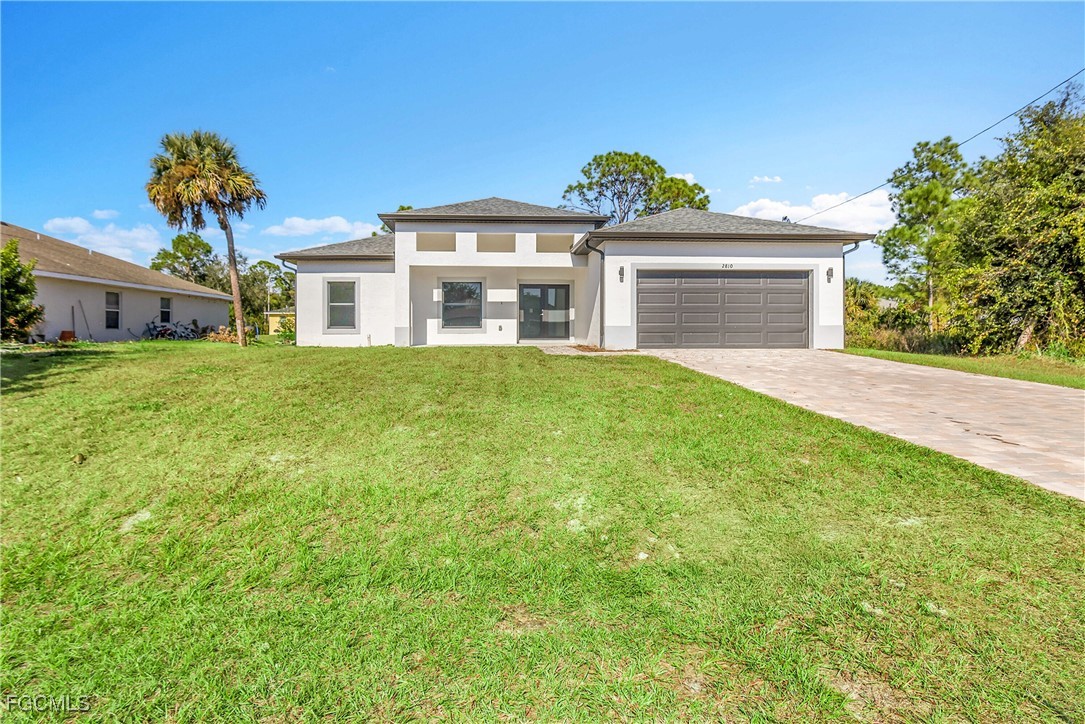 2810 44th Street Southwest Lehigh Acres, FL 33976 - Photo 1 of 31 a front view of a house with a garden and yard