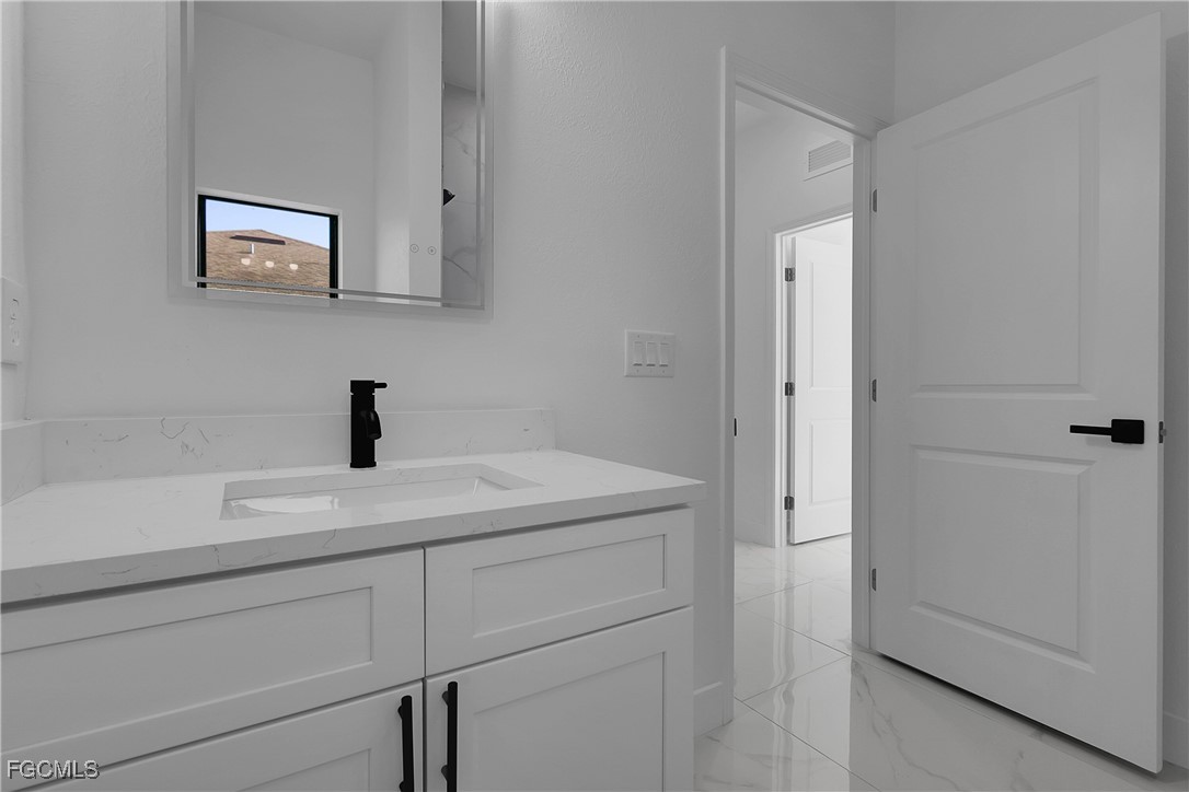 2810 44th Street Southwest Lehigh Acres, FL 33976 - Photo 29 of 31 a bathroom with a sink and vanity