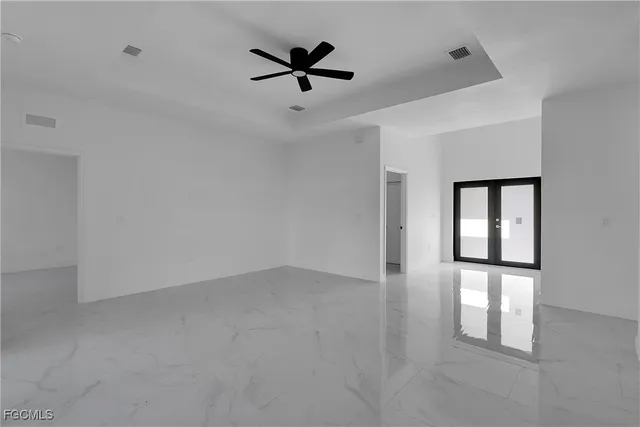 an empty room with windows and ceiling fan