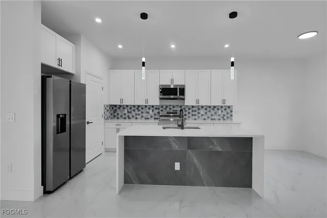 a view of kitchen with center island stainless steel appliances and cabinets