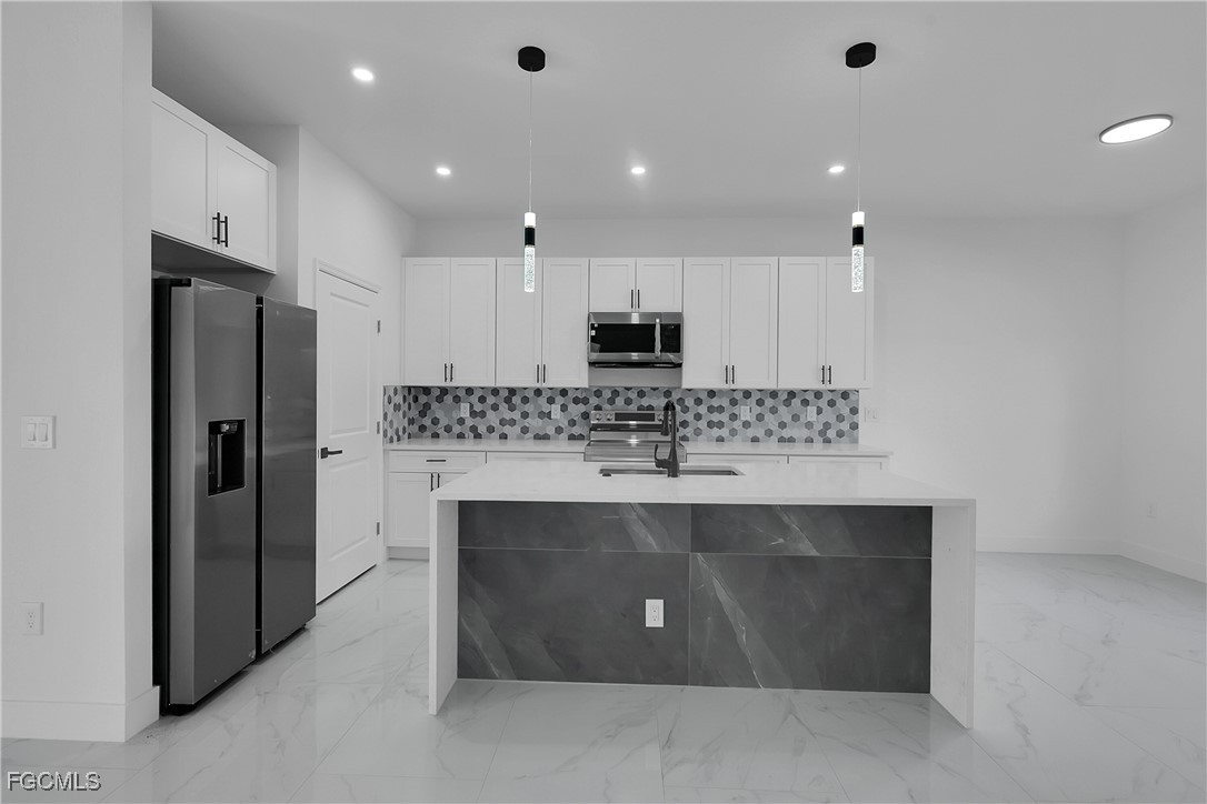 2810 44th Street Southwest Lehigh Acres, FL 33976 - Photo 7 of 31 a view of kitchen with center island stainless steel appliances and cabinets